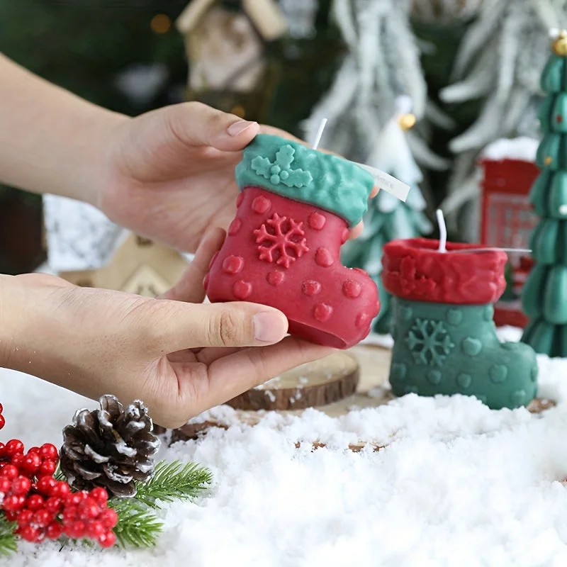 Bougie en forme de bas au milieu d'autres décorations de Noël